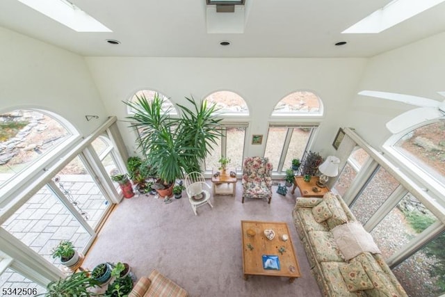 living room with a skylight and high vaulted ceiling