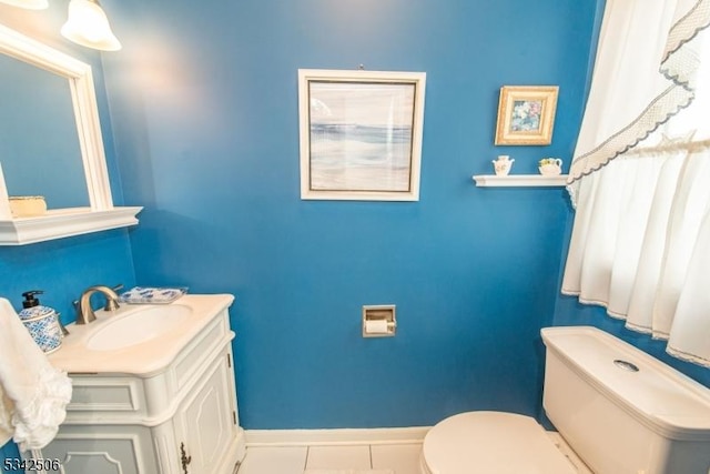 half bath featuring baseboards, vanity, toilet, and tile patterned floors