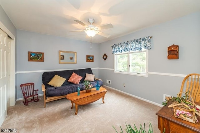 carpeted living area featuring ceiling fan and baseboards