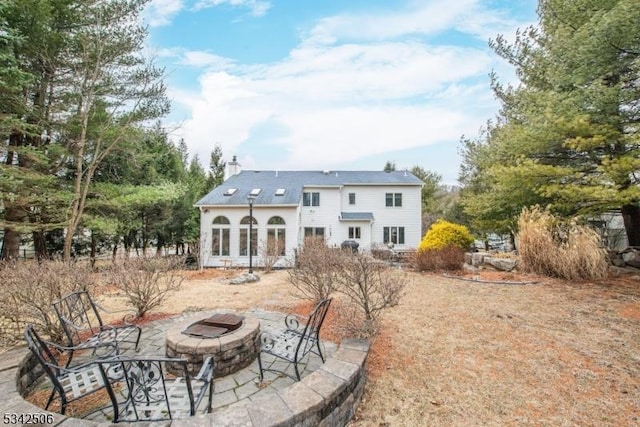 rear view of property with a patio, an outdoor fire pit, and a chimney