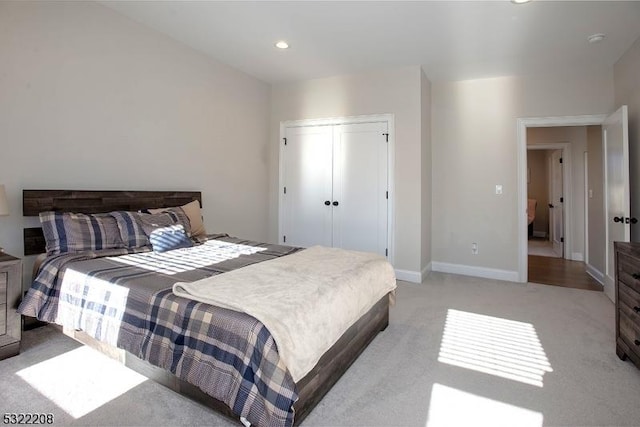 bedroom featuring recessed lighting, a closet, light colored carpet, and baseboards