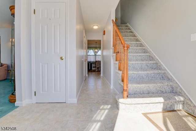 stairway with tile patterned floors and baseboards