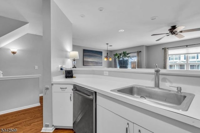 kitchen featuring light wood-style flooring, light countertops, stainless steel dishwasher, white cabinetry, and a sink