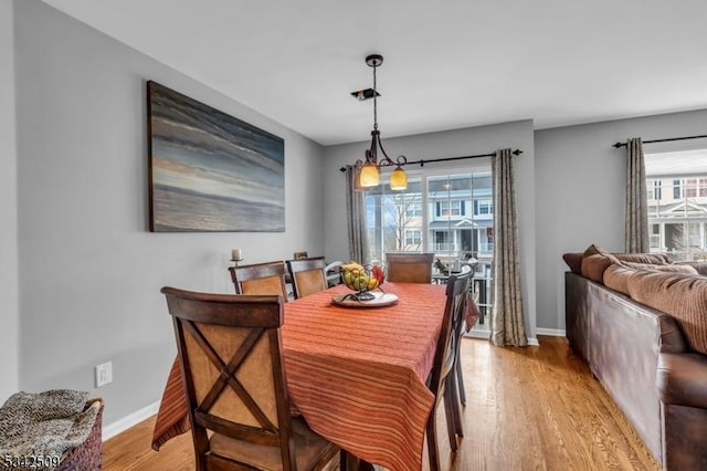 dining area featuring baseboards and light wood finished floors