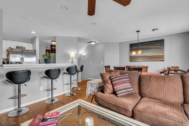 living area featuring baseboards, wood finished floors, and recessed lighting