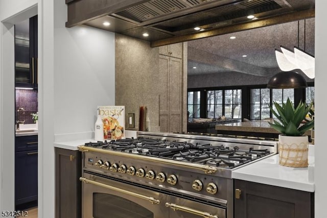 kitchen featuring a sink, range with two ovens, beamed ceiling, and custom exhaust hood