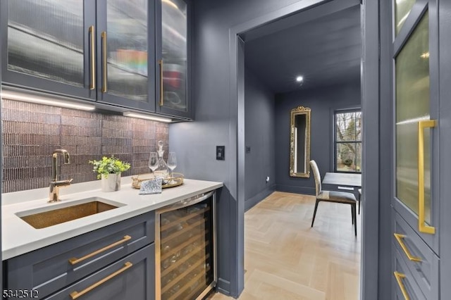 bar featuring wine cooler, tasteful backsplash, a sink, wet bar, and baseboards