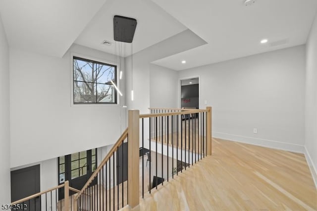 hallway with recessed lighting, visible vents, an upstairs landing, wood finished floors, and baseboards