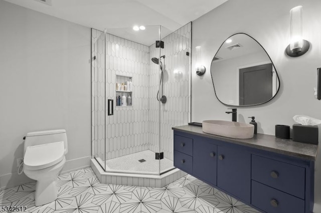 full bathroom featuring a stall shower, baseboards, visible vents, toilet, and vanity