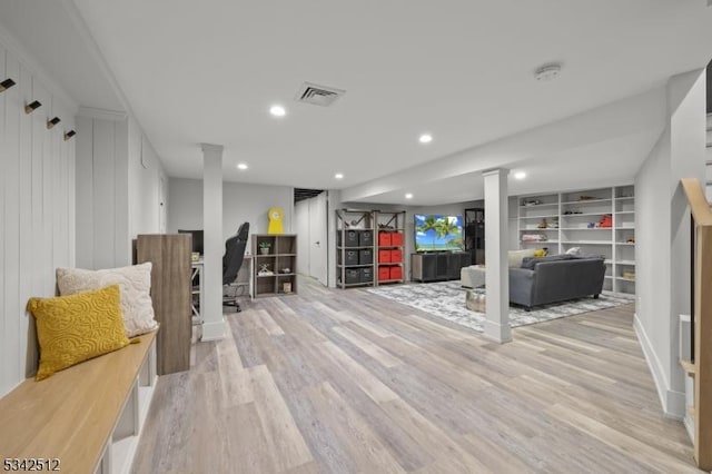 basement featuring light wood-type flooring, visible vents, and recessed lighting