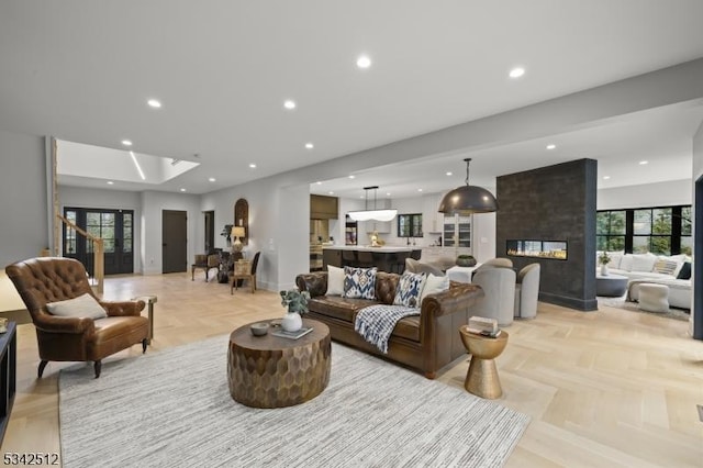 living room featuring baseboards, a multi sided fireplace, and recessed lighting