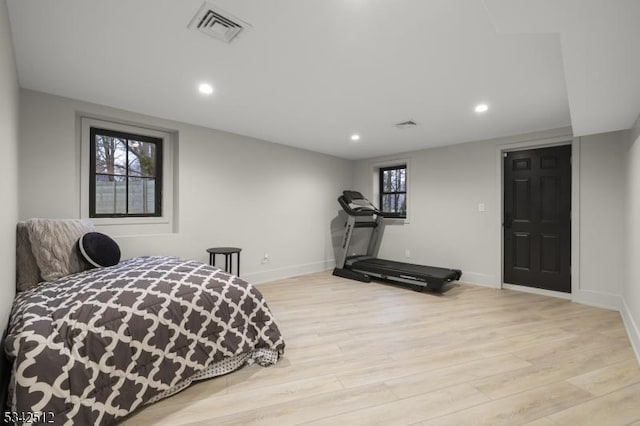 bedroom with visible vents, baseboards, and wood finished floors