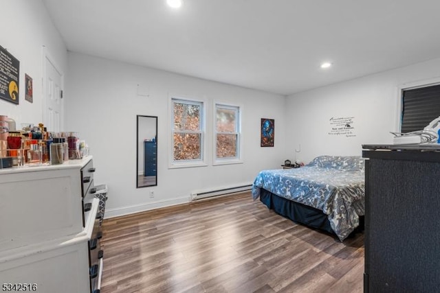 bedroom featuring recessed lighting, wood finished floors, baseboards, and a baseboard radiator