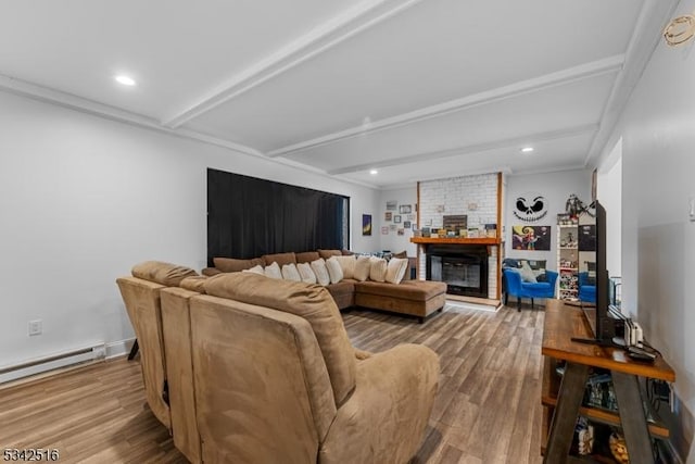 living room featuring a baseboard heating unit, beam ceiling, a brick fireplace, and wood finished floors