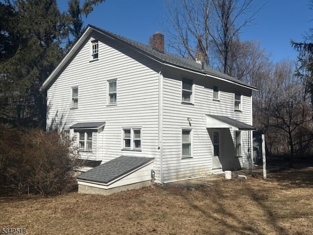 rear view of house featuring a chimney