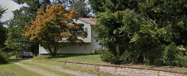 view of side of home featuring a lawn and driveway