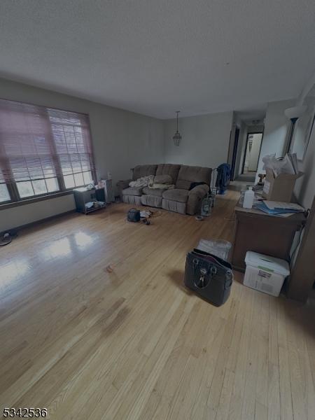 unfurnished living room featuring a textured ceiling and wood finished floors