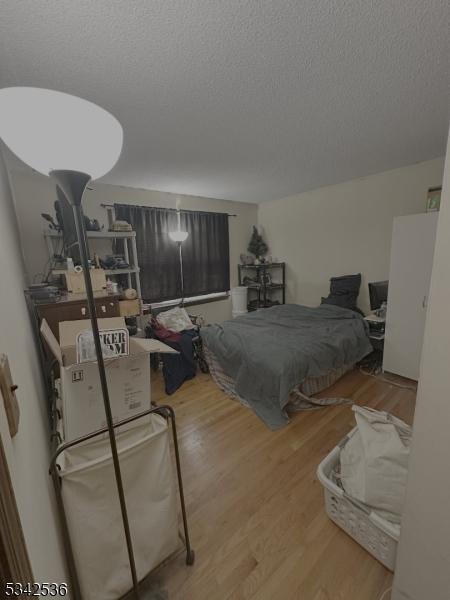 bedroom featuring a textured ceiling and wood finished floors