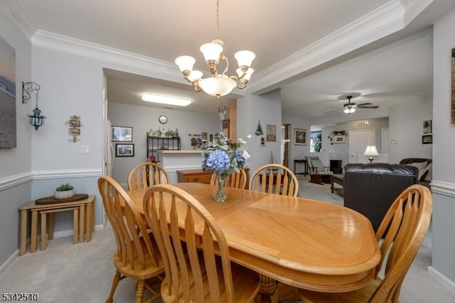 dining room featuring baseboards, light colored carpet, ornamental molding, and ceiling fan with notable chandelier