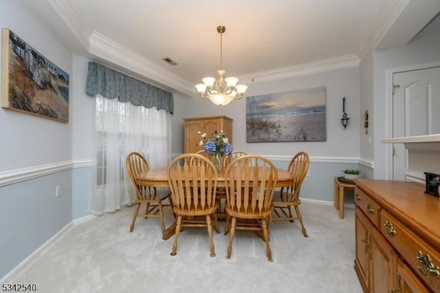 dining room featuring a chandelier, light colored carpet, crown molding, and baseboards