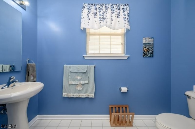 bathroom with tile patterned flooring, toilet, and baseboards