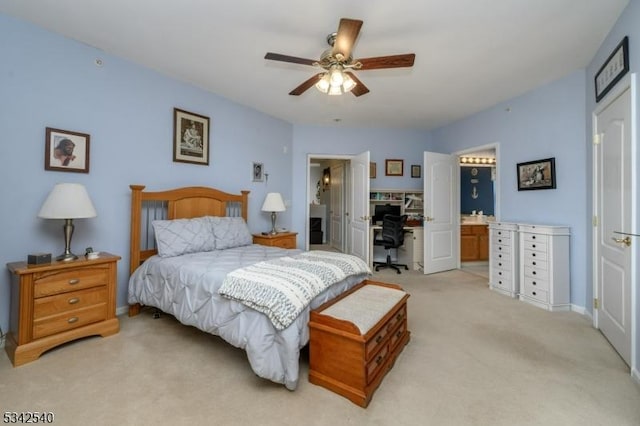 bedroom with a ceiling fan, light colored carpet, baseboards, and connected bathroom