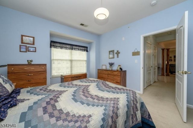 bedroom featuring visible vents, light carpet, and baseboards