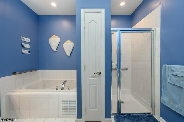 bathroom featuring visible vents, a stall shower, and a bath