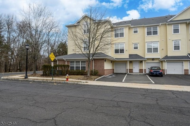 multi unit property featuring an attached garage and brick siding