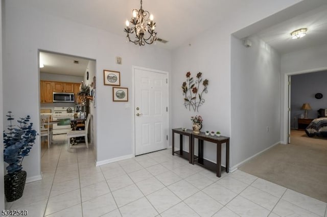 entryway featuring light tile patterned floors, a chandelier, and light carpet