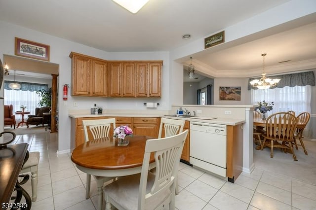 kitchen featuring a sink, a peninsula, light countertops, and white dishwasher