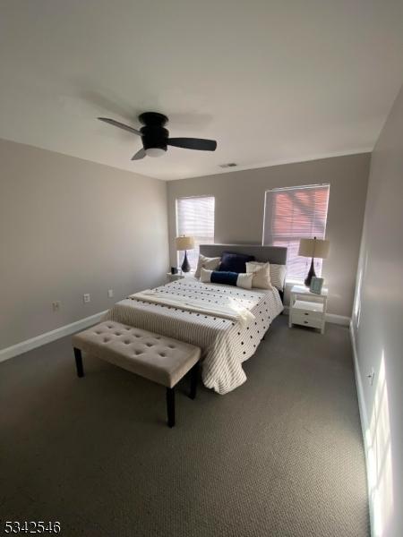 bedroom featuring carpet floors, visible vents, ceiling fan, and baseboards