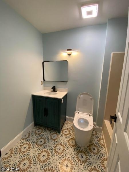 bathroom with toilet, tile patterned floors, vanity, and baseboards