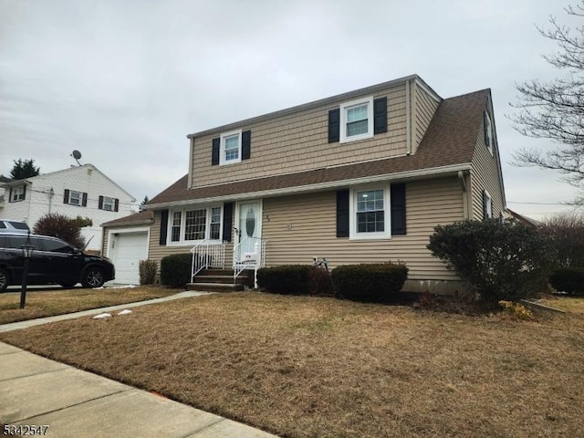 view of front of home featuring a garage, a shingled roof, and a front yard