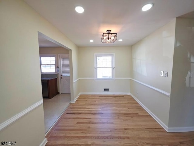 unfurnished dining area featuring recessed lighting, light wood-type flooring, visible vents, and baseboards