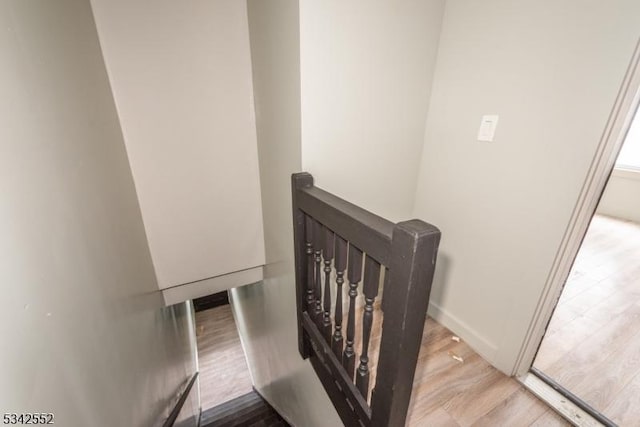 stairway featuring baseboards and wood finished floors