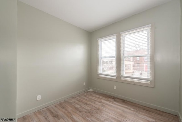 unfurnished room featuring light wood finished floors and baseboards