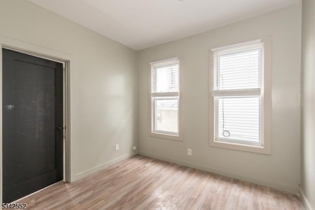 empty room with light wood-style floors and baseboards