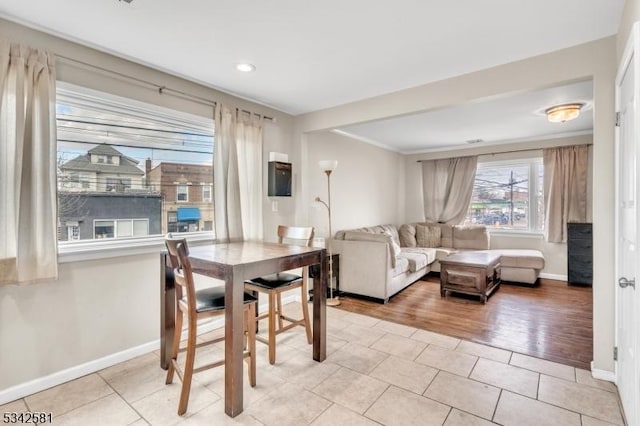 dining room with ornamental molding, baseboards, and light tile patterned floors