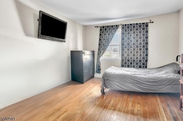 bedroom with wood finished floors and baseboards