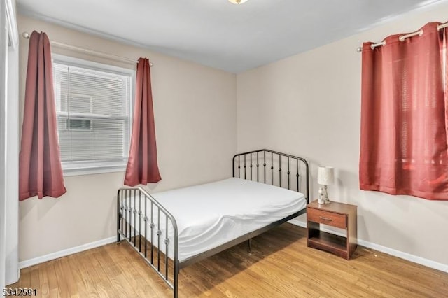 bedroom featuring baseboards and wood finished floors