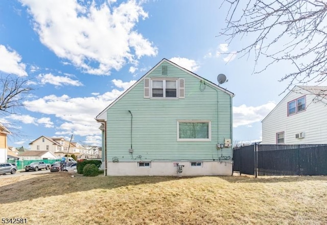 rear view of house featuring fence and a yard