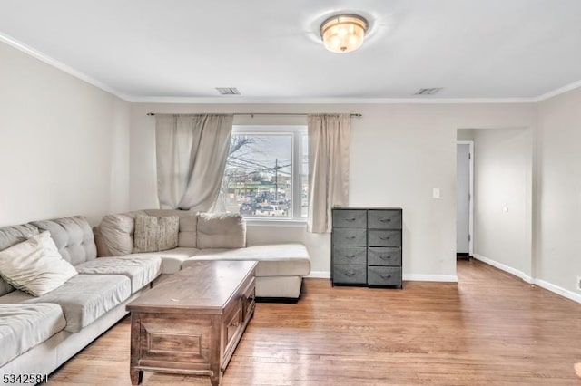 living area featuring baseboards, light wood-type flooring, and crown molding