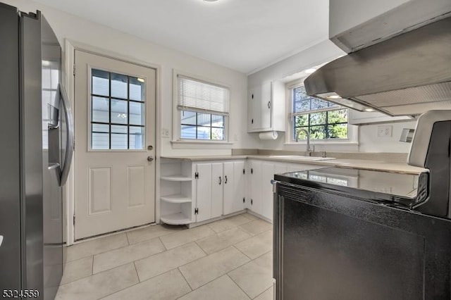 kitchen featuring a sink, white cabinets, light countertops, open shelves, and stainless steel fridge