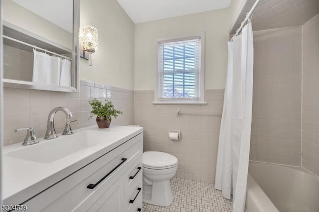 bathroom featuring tile walls, toilet, shower / bath combo with shower curtain, vanity, and tile patterned floors