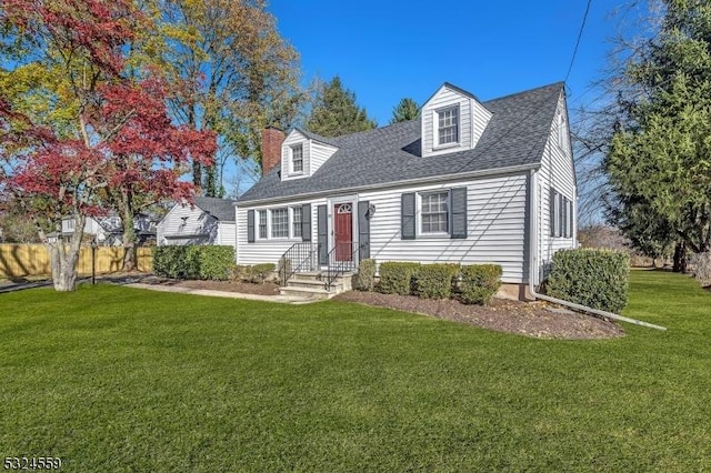 cape cod-style house featuring roof with shingles, a chimney, fence, and a front yard