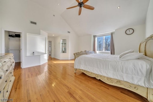 bedroom featuring visible vents, baseboards, ceiling fan, light wood-style floors, and high vaulted ceiling