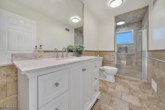 bathroom with visible vents, toilet, a shower stall, and tile walls