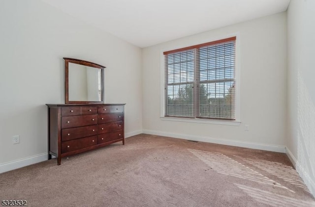 unfurnished bedroom featuring carpet and baseboards