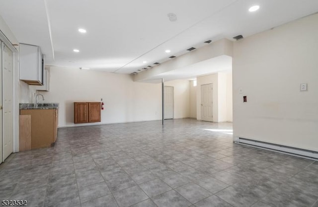 interior space featuring a baseboard heating unit, a sink, and recessed lighting